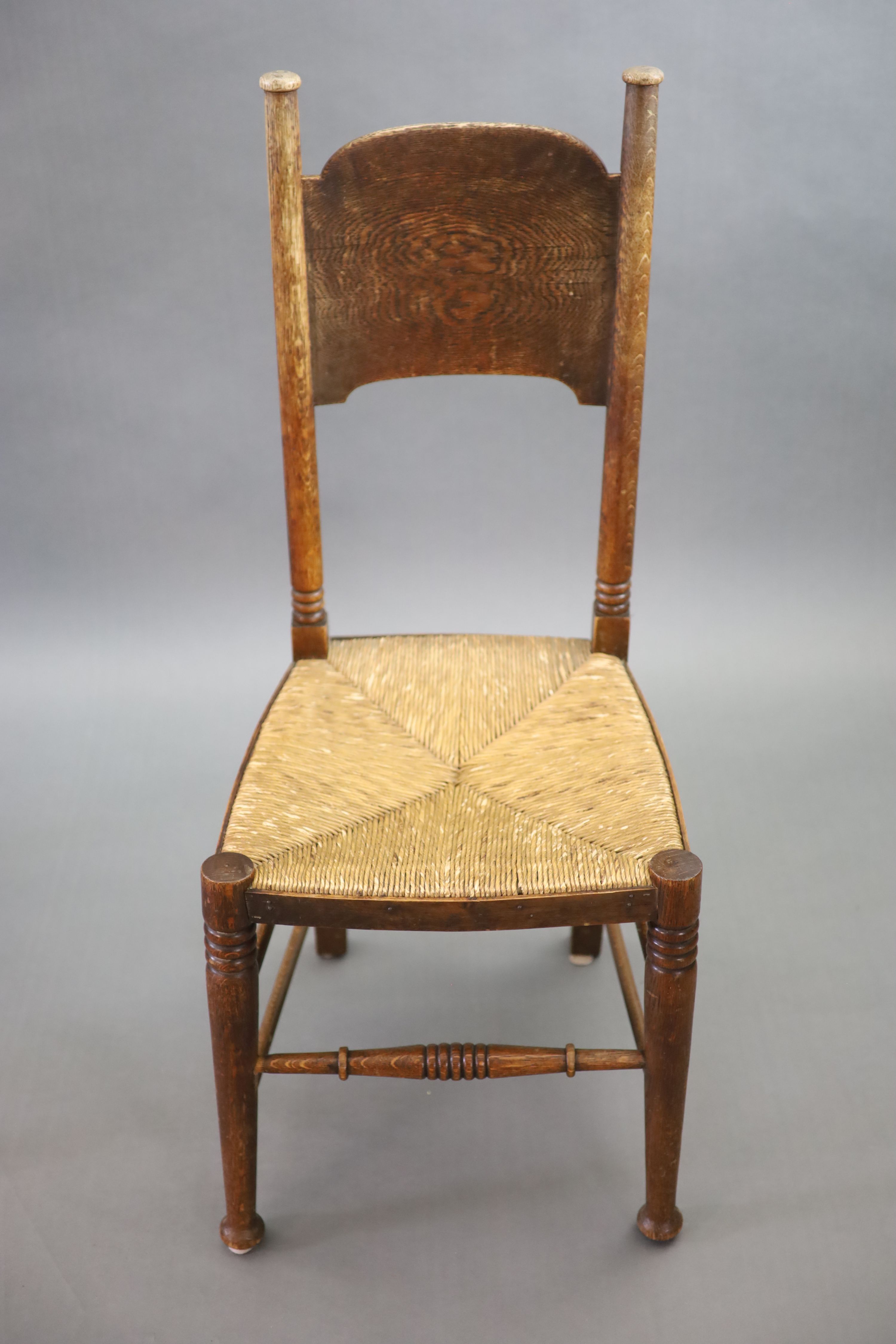 A set of six oak chairs, including a pair of carvers, in the Glasgow School manner by William Birch, High Wycombe, carvers W.58cm D.54cm H.109cm